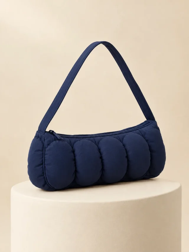 Bubble Row Baguette in Ink Navy, front view on a cream plinth