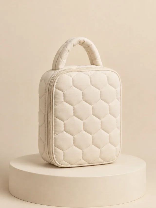 Honeycomb Hex Bag in Cream, front view on a cream plinth