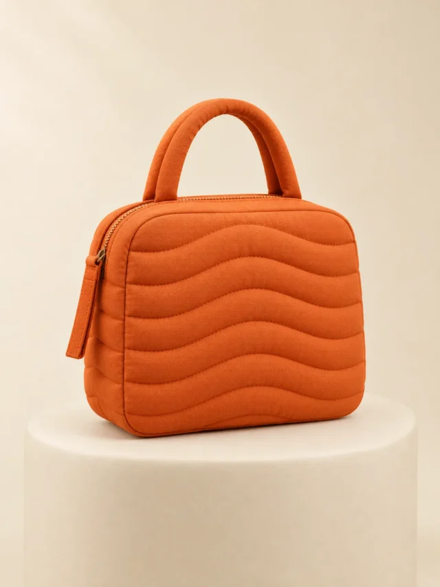 Ripple Channel Mini in Persimmon, front view on a cream plinth
