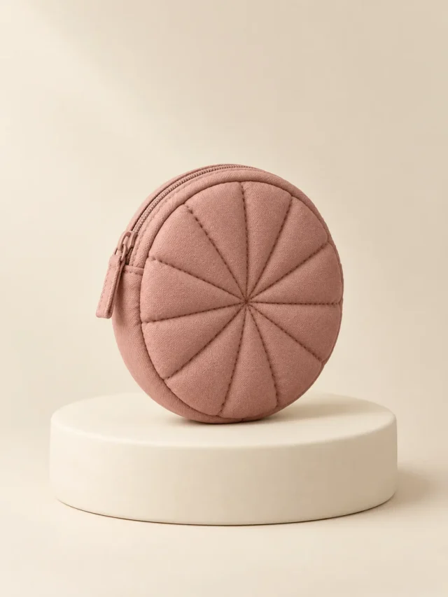 Round Coin Puff in Clay Pink, front view on a cream plinth