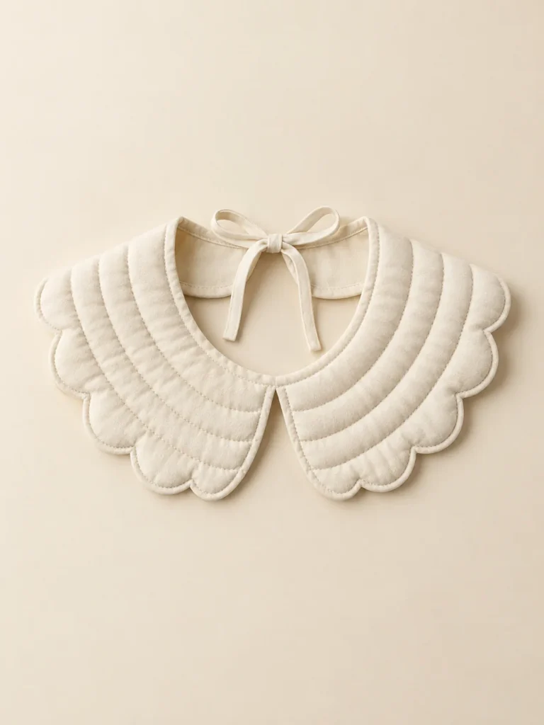 Scallop Puff Collar in Cream, front view on a cream plinth