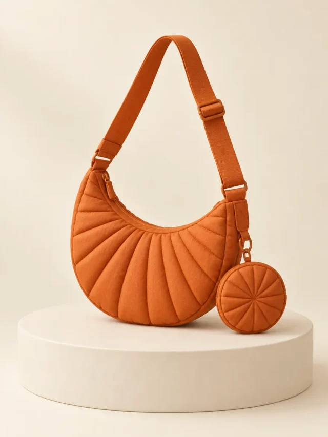Sling & Coin Set in Persimmon, front view on a cream plinth
