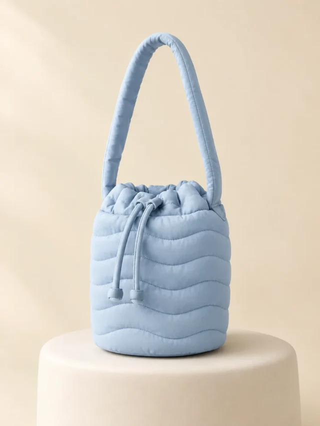 Wave Bucket Mini in Powder Blue, front view on a cream plinth