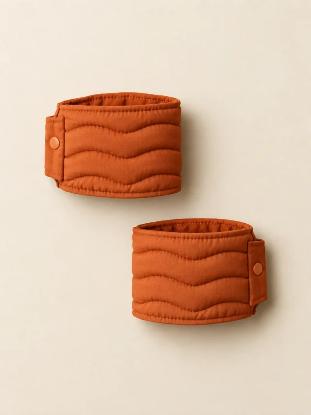 Wave Cuff Pair in Persimmon, front view on a cream plinth